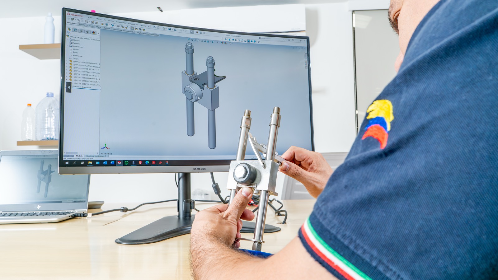 Ingeniero de MOMA revisando una pieza mecanizada frente a su diseño 3D en pantalla